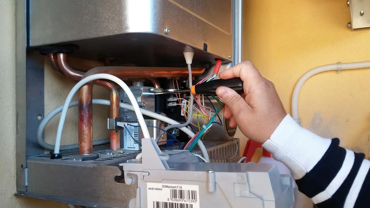 Technician repairing the internal controls of a water heater